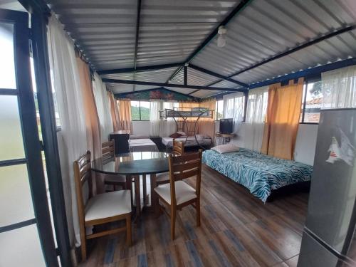 Habitación con mesa, cama y dormitorio. en Hospedaje Rural Cabañas Mirador de la Cascada, en Santa Rosa de Cabal