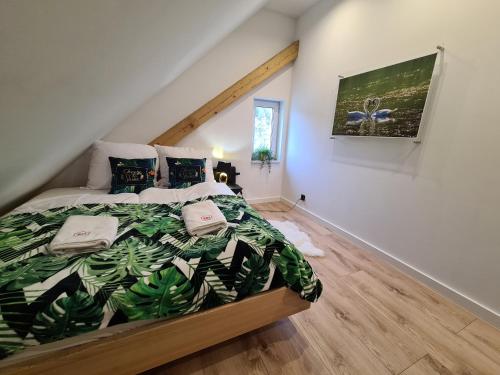1 dormitorio con 1 cama con edredón verde en Apartament Ptasia Ostoja - 5D Apartamenty en Świeradów-Zdrój