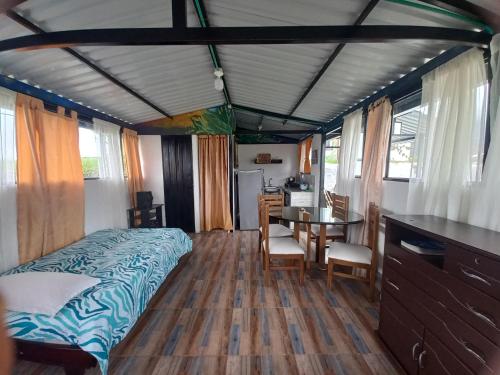 1 dormitorio con cama, escritorio y mesa en Hospedaje Rural Cabañas Mirador de la Cascada, en Santa Rosa de Cabal