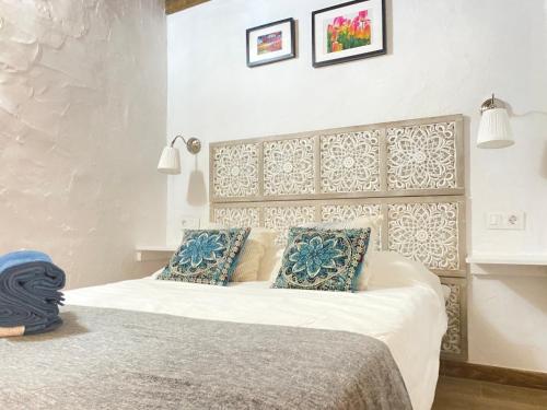 una camera da letto con un letto con cuscini blu e bianchi di Mardelava a Tinajo