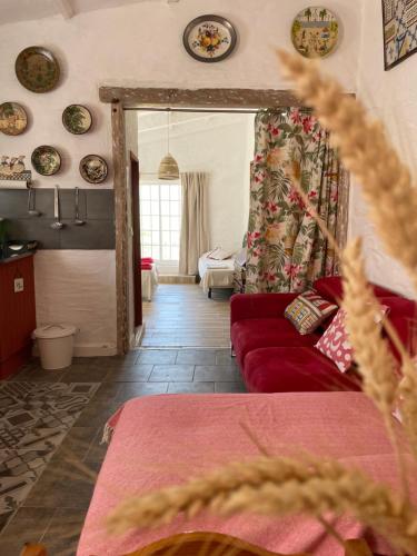 sala de estar con sofá rojo y placas en la pared en Monte Carrascal Guesthouse, en Salir