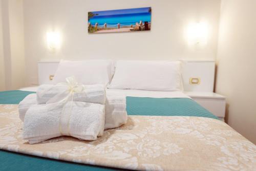 a bed with towels and a picture of a beach at CVM Mare Luna in Maiori
