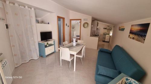 a living room with a table and a blue couch at Casa Il Sole in Piraino
