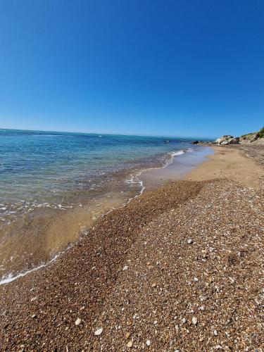 a beach with rocks and the ocean on a clear day at Tendu' Punta Bianca Glamping Camp in Palma di Montechiaro