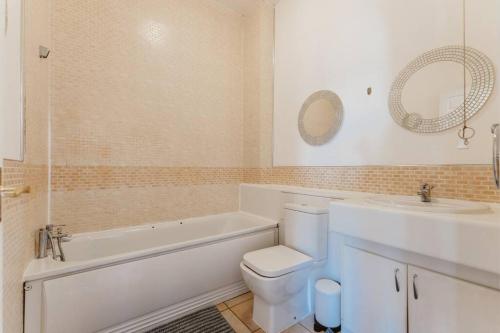 ein Badezimmer mit einer Badewanne, einem WC und einem Waschbecken in der Unterkunft Comfortable Double Room for Your London Getaway in London