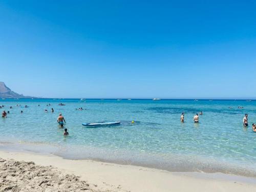 a group of people in the water at the beach at Casa delle Sirene in Isola delle Femmine