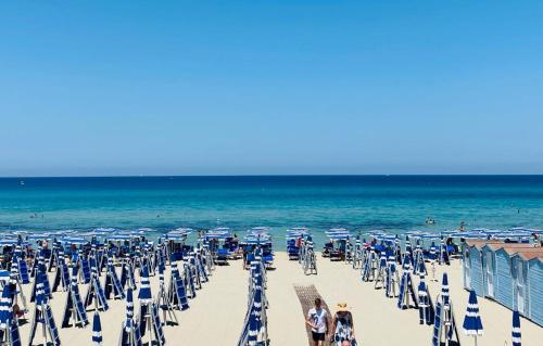 a beach with chairs and umbrellas and the ocean at Casa delle Sirene in Isola delle Femmine