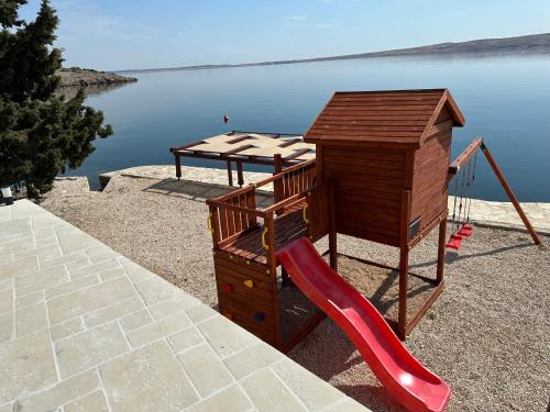 a playground with a red slide and a playset at Family Villa Tiffany&more in Barić Draga