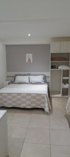 1 dormitorio con 1 cama grande en una habitación blanca en Abrazo Fueguino: calido comodo y centrico -WiFi en Ushuaia