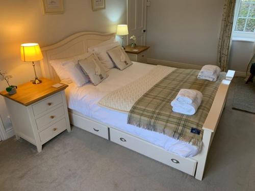 a bedroom with a large white bed with a night stand at Cliff Stud Retreat - Luxury lodges and cosy cottages in Helmsley