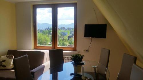 a dining room with a table and a window at Apartament z widokiem na góry in Ząb