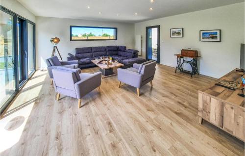 a living room with a blue couch and chairs at Nice Home In Kerlouan With Wifi in Kerlouan