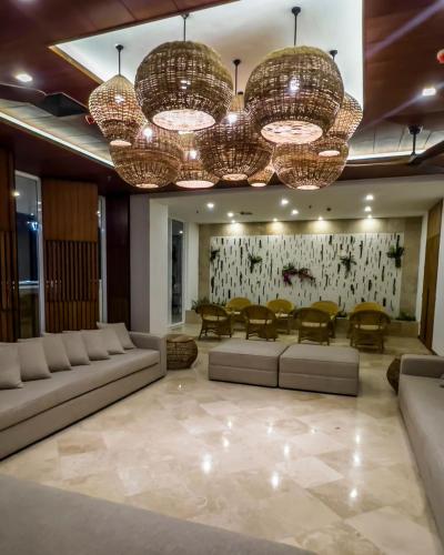 a living room with couches and tables and chandeliers at Eurobuilding Hotel & Suites Lecheria in El Morro de Barcelona