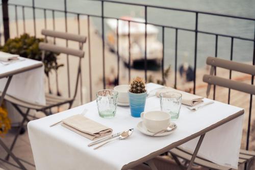 einen weißen Tisch mit Tellern und Tassen auf einem Balkon in der Unterkunft Torre a Mare Porto Venere in Porto Venere