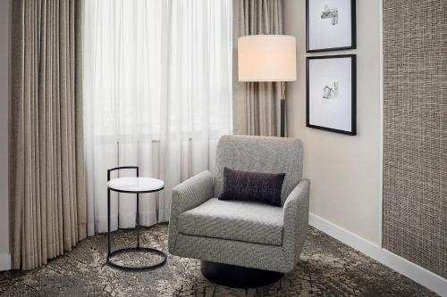 a chair and a lamp in a room with a window at Sheraton Hamilton Hotel in Hamilton