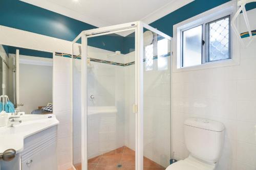 a bathroom with a shower and a toilet and a sink at 5 Brolga Place Peregian Beach in Peregian Beach
