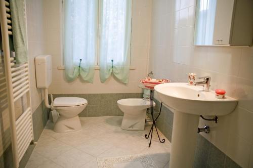 a bathroom with a sink and a toilet and a window at La Meridiana Affittacamere in Colorno