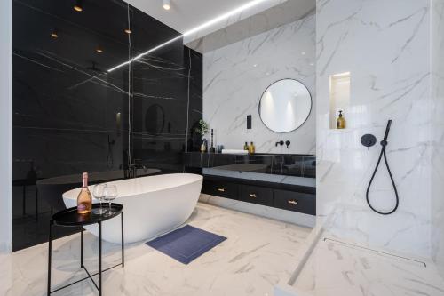 a bathroom with a white tub and a sink at Basilica Presidential panorama suits in Budapest