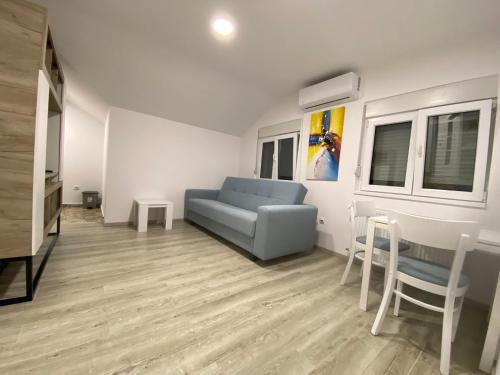 a living room with a blue couch and chairs at Apartman MIMI in Vrnjačka Banja