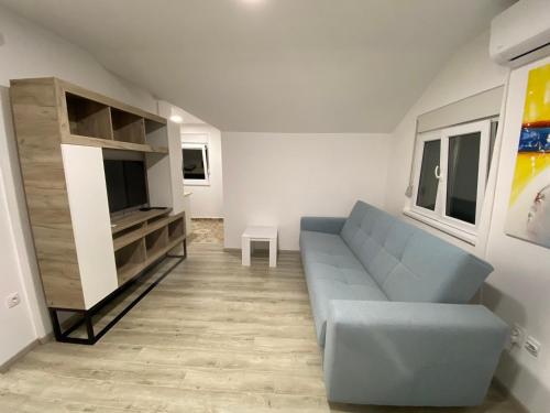 a living room with a blue couch and a tv at Apartman MIMI in Vrnjačka Banja