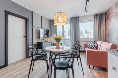 uma sala de estar com uma mesa e cadeiras e um sofá em Platinum Premium Apartment em Grudziądz