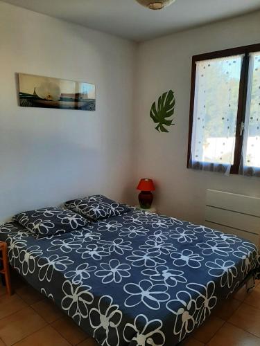 une chambre avec un lit avec un couvre-lit bleu et blanc dans l'établissement Villa avec jardin à Poussan avec piscine privée ouverte toute l'année, à Poussan