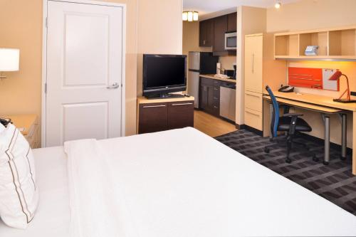 a hotel room with a bed and a desk with a computer at TownePlace Suites by Marriott Las Vegas Henderson in Las Vegas