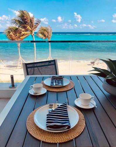 a table with plates and cups on a beach at Club Suites at Rum Point in Driftwood Village