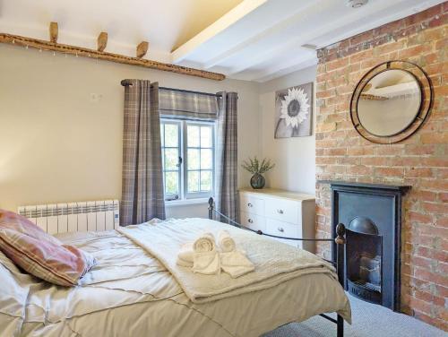 a bedroom with a large bed with towels on it at Piemans Cottage in Pulborough