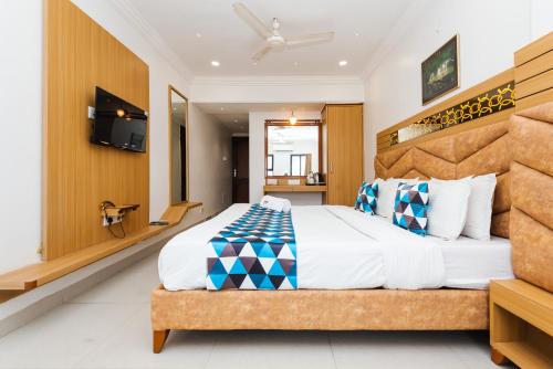 a bedroom with a large bed and a television at Hotel Galaxy Opp Surat Railway Station in Surat