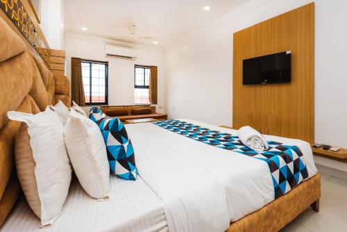 a bedroom with a large bed with a television on a wall at Hotel Galaxy Opp Surat Railway Station in Surat