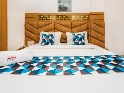 a bedroom with a bed with a checkered floor at Hotel Galaxy Opp Surat Railway Station in Surat