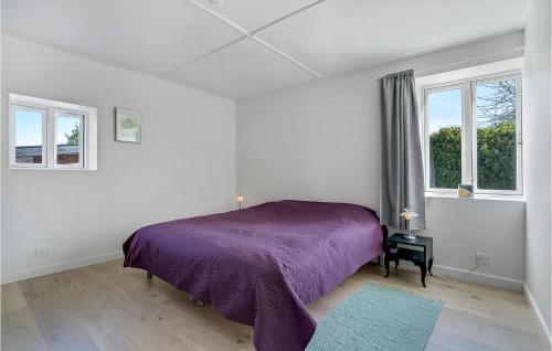 1 dormitorio con 1 cama de color púrpura y 2 ventanas en 3 Bedroom Awesome Home In Sams en Nordby