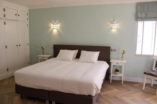 a bedroom with a large bed with two white pillows at Casa Carioca Carvoeiro in Carvoeiro