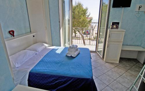 un dormitorio con una cama con un osito de peluche sentado en ella en Hotel Capital, en Cupra Marittima