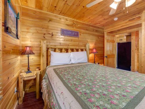 1 dormitorio con 1 cama en una cabaña de madera en Truly Blessed, 3 Bedrooms, Hot Tub, Sleeps 10 en Gatlinburg