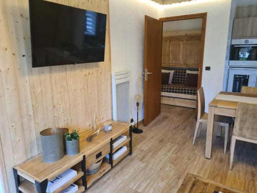 ein Wohnzimmer mit einem Tisch und einem Fernseher an der Wand in der Unterkunft Luxury holidays apartment Praz sur Arly in Praz-sur-Arly