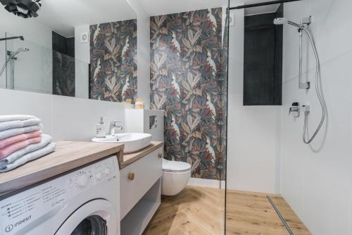 ein Bad mit einer Dusche, einer Waschmaschine und einem Trockner in der Unterkunft Platinum Premium Apartment in Graudenz