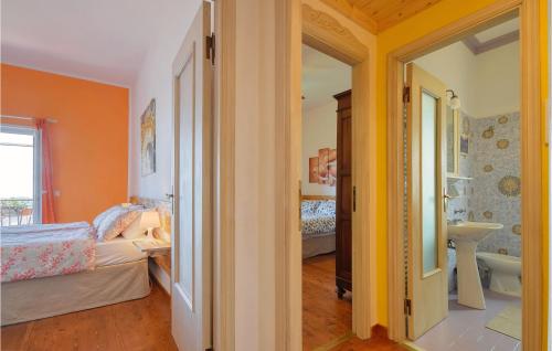 1 dormitorio con paredes de color naranja, 1 cama y baño en Nice Home In Castiglione Chiavarese With Kitchen, en Castiglione Chiavarese