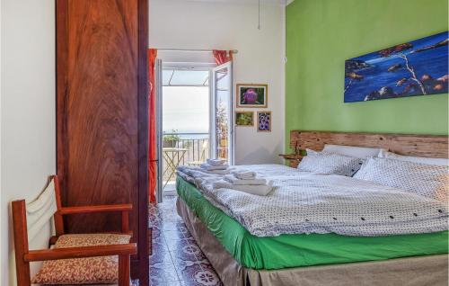 1 dormitorio con 1 cama, 1 silla y 1 ventana en Nice Home In Castiglione Chiavarese With Kitchen, en Castiglione Chiavarese