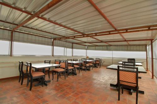 a group of tables and chairs in a room at Flagship Manu Residency Near Ascendas Park Square Mall in Bangalore