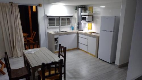 una pequeña cocina con mesa y refrigerador blanca en Tiké en Ostende
