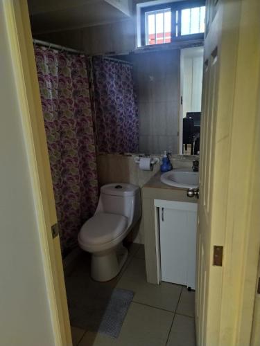 a bathroom with a toilet and a sink at Tormalyn Spa in Coquimbo