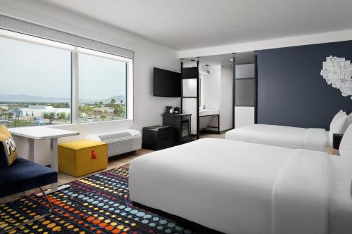 a hotel room with two beds and a window at Aloft Henderson in Las Vegas
