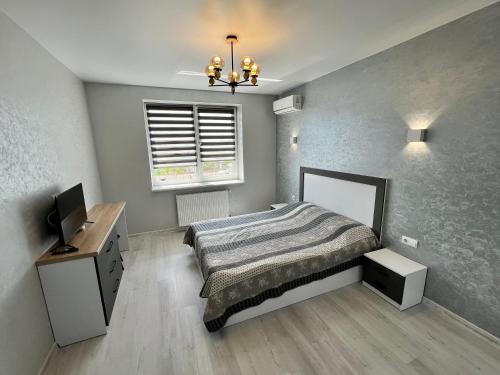 a bedroom with a bed and a desk and a television at Apartment for you in Ivano-Frankivsʼk