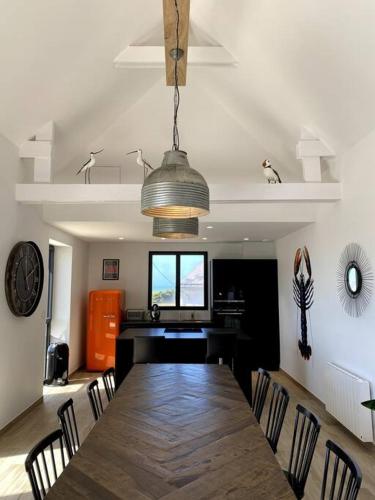 une salle à manger avec une grande table et des chaises en bois dans l'établissement La Cabane des Pêcheurs, à Quiberon