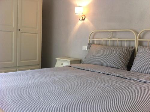 a bed with two pillows and a light on the wall at Skipper White Guest House in Trevignano Romano