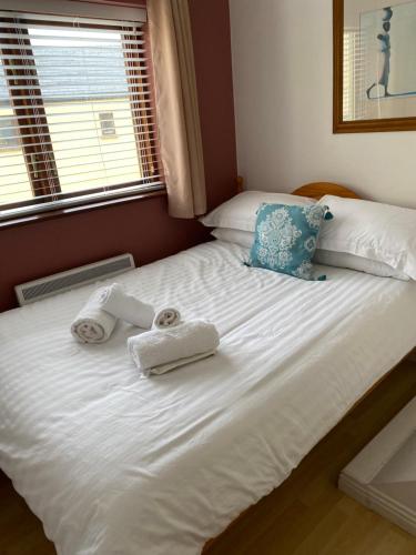 a bedroom with a bed with towels on it at Village centre apartment in Lahinch