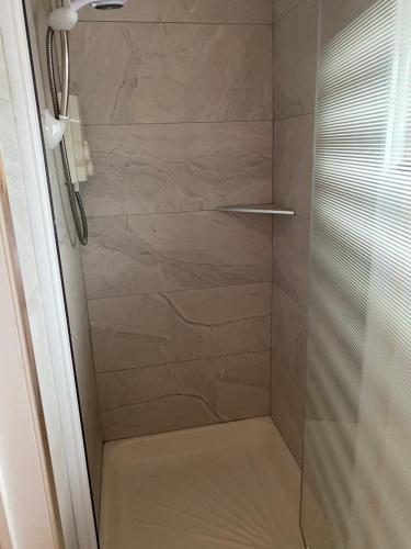 a shower with a glass door in a bathroom at Village centre apartment in Lahinch