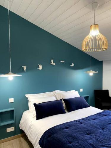 a blue bedroom with a bed with birds on the wall at La Cabane des Pêcheurs in Quiberon